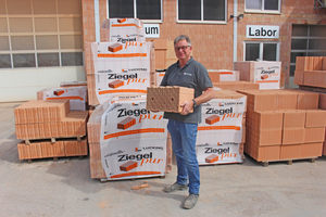  » Technical plant manager Claus Lohmann with the „mother of all Lücking bricks“, a plane brick from the Ziegelpur technology line. 