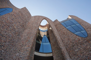  Each brick was specially fit into the complex curvature of the concrete walls, the overall brickwork lying flush with the curved steel frames and glass elements of the facade 