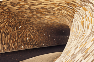  » The interior of the tunnel has a warm atmosphere thanks to the colours and curved shape of the shingles and the cast brick-shaped light 