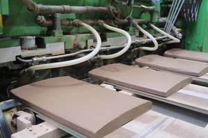  » Fig. 3: View into the roof tile press: During pressing, water is pressed out of the clay, which is extracted through the upper mould 