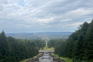  » Blick vom Fuß des Oktogons auf das Schloss Wilhelmshöhe und die Stadt im Hintergrund. Das Tagungshotel verbirgt sich hinter den Bäumen links vom Schloss 
