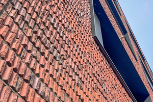  » Der die raue Anmutung der Fassade ausmachende gebrochene Ziegel entstand durch gezieltes Abschlagen per Hand 