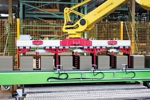  » A robot with a special gripper sets the wet products on the dryer loading pallets 