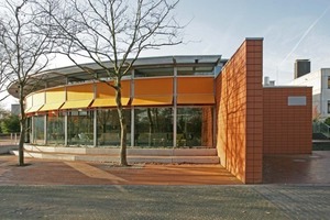  &gt;&gt; A facade wing separates the light, glass southern section of the cafeteria from the solid-looking kitchen block in the north 