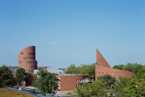  &gt;&gt; Die Erweiterungsbauten aus der Vogelperspektive: links im Bild der sich spiralförmig in die Höhe windende 6-geschossige Nordturm und als Gegenpol dazu, rechts, der gleichermassen rund ausgeformte Südturm als Abschluss des ebenfalls erweiterten niedrigeren Schultrakts. 