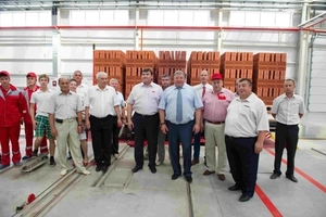  &gt;&gt;4 Participants of the ceremonial opening of the brick plant with the finished product in the background  