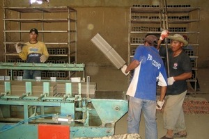  ››7 The freshly pressed bricks are taken off manually with forks after the block cutter and placed on frame cars 