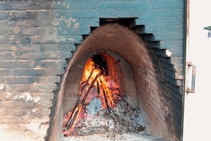  »3 View into the stoking channel of the kiln during firing, the provisional metal door was used as a heat shield to protect the kiln workers  